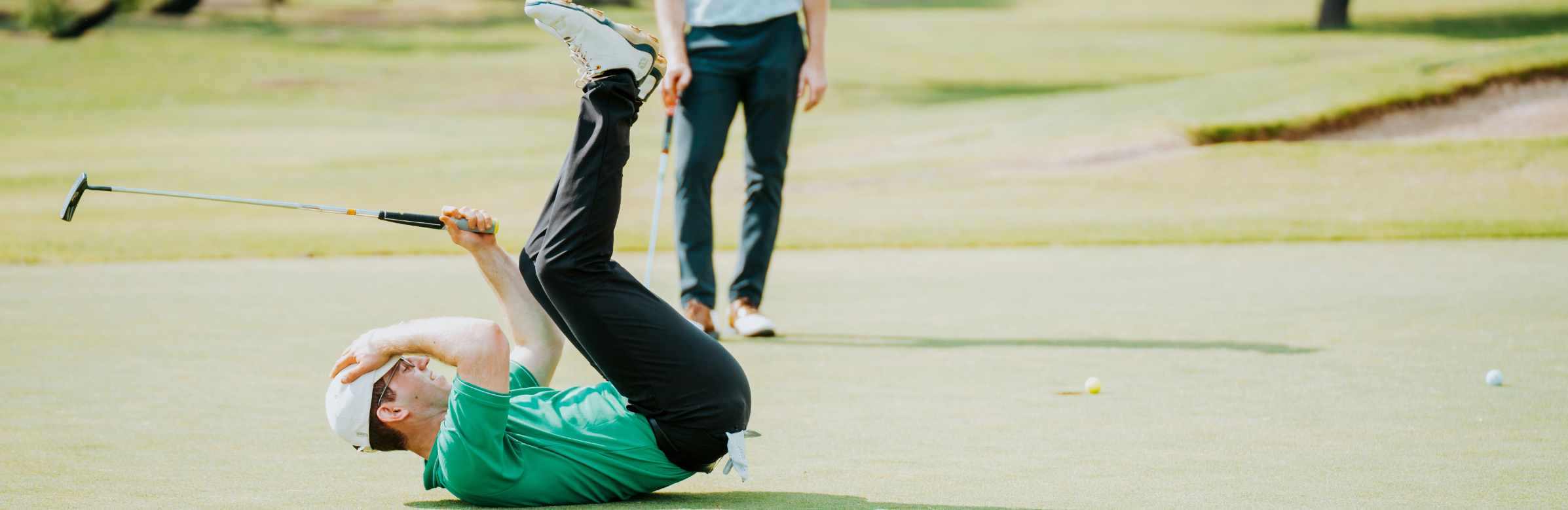 person lying on their back on a golf course