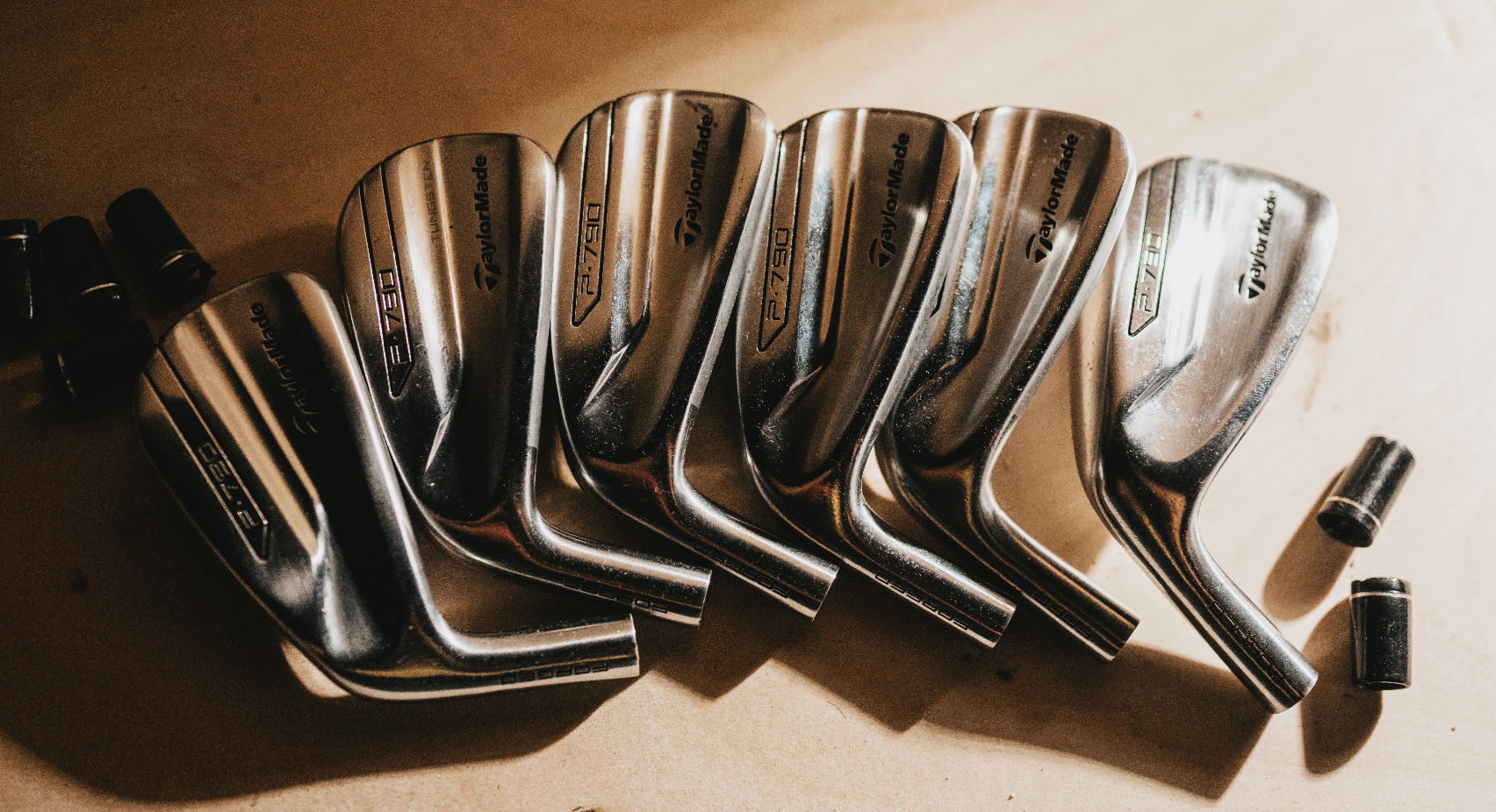 image of P790 golf club heads laid out across the table.