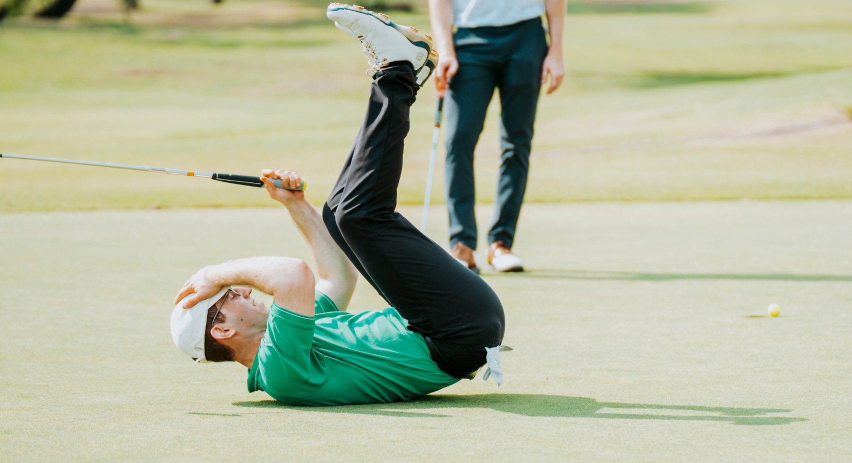 person lying on their back on a golf course