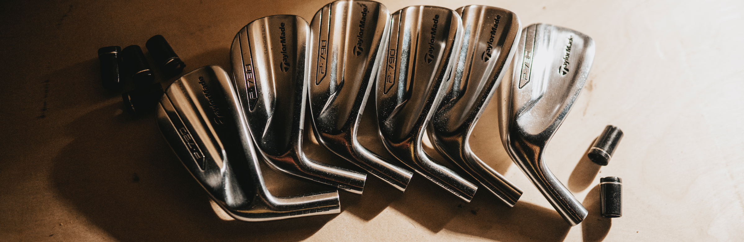 image of P790 golf club heads laid out across the table.